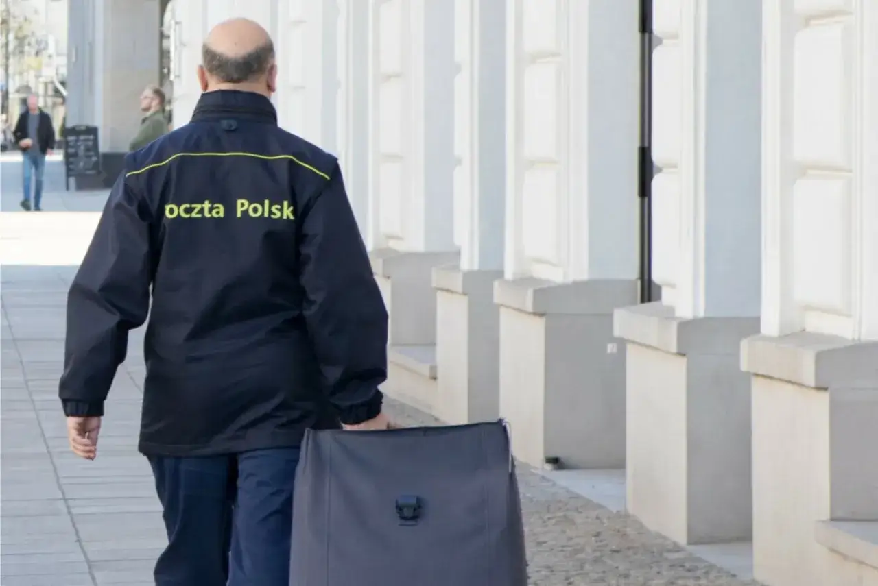 Listonosz Poczty Polskiej z torbą, zastanawiasz się, ile zarabia listonosz?